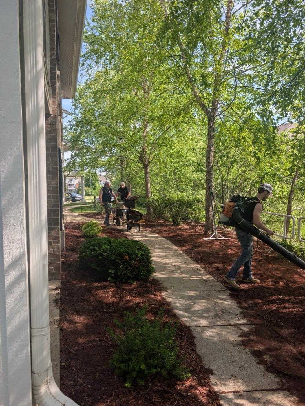 Crew clearing a walkway with a backpack blower