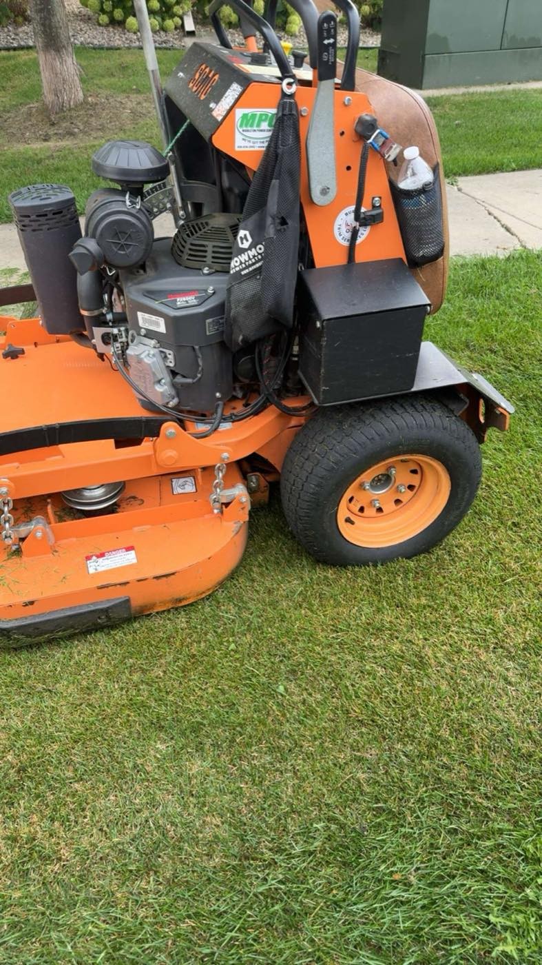 Close-up of a stand-on mower deck on freshly cut grass