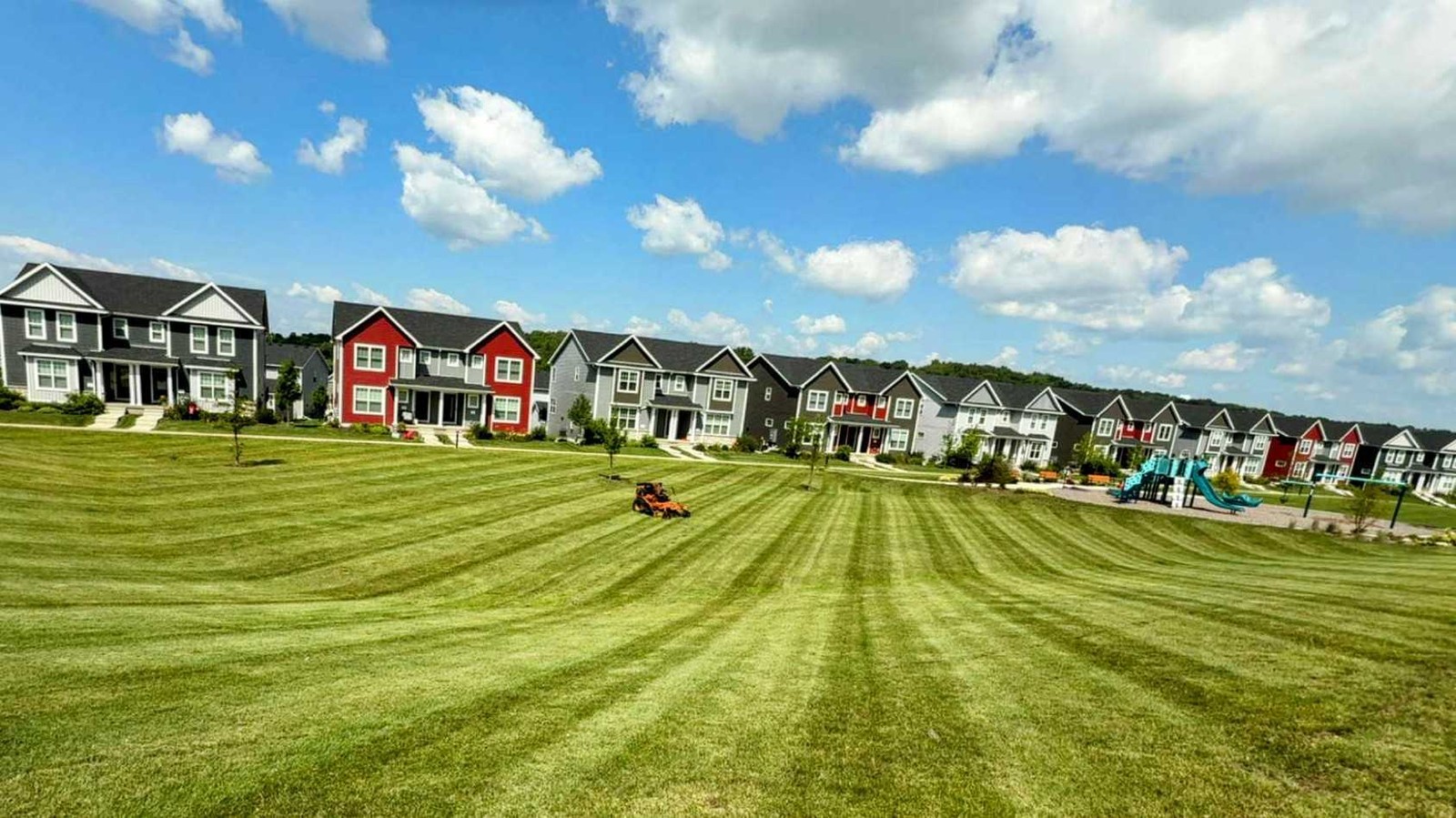 Stand-on mower parked in a freshly cut field