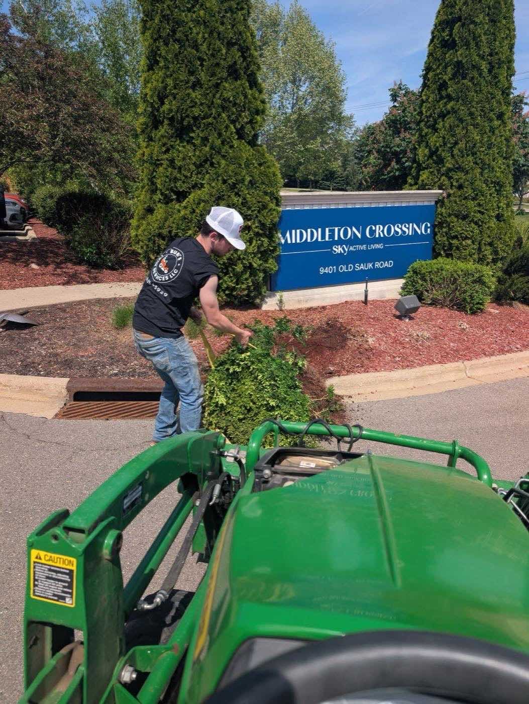 Crew mulching landscape beds at a commercial property entrance