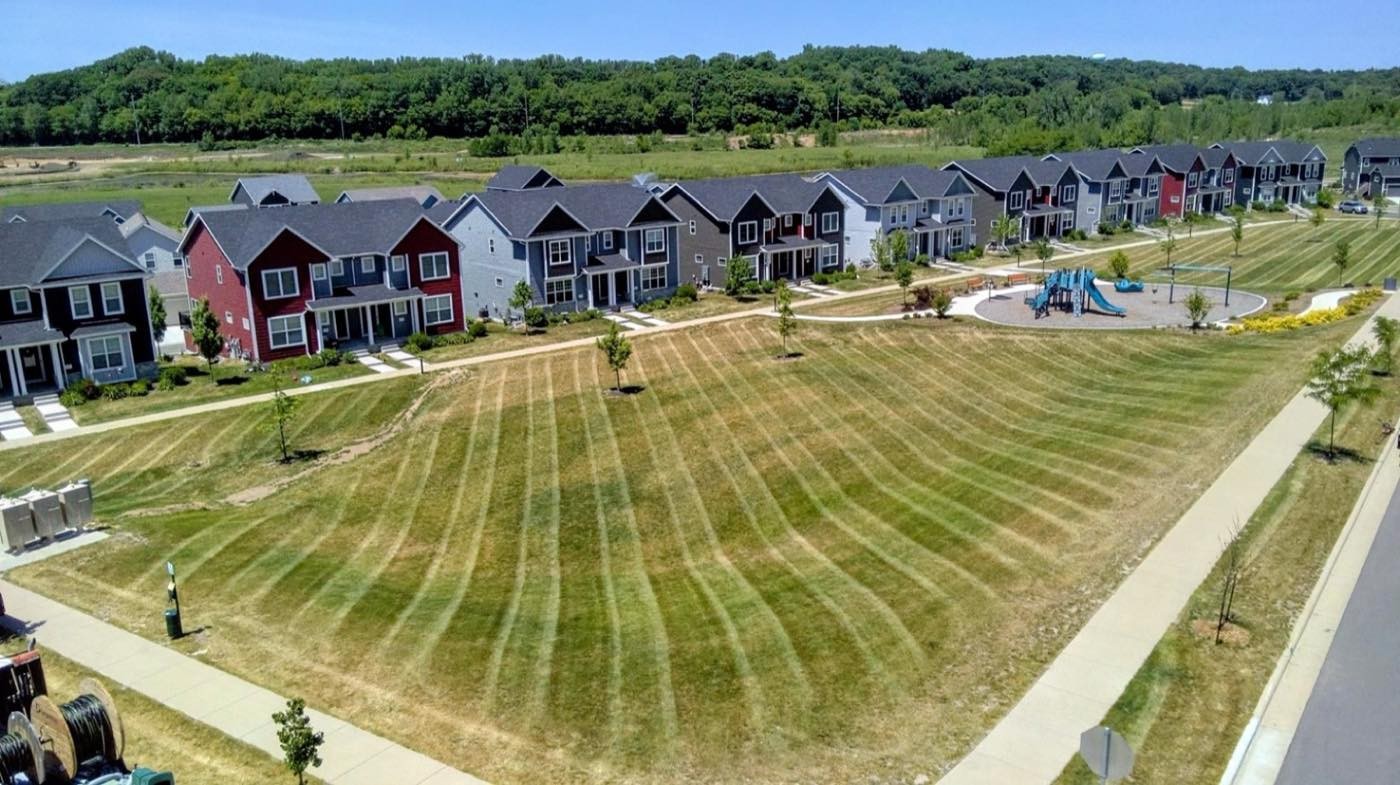 Aerial view of a townhome community lawn mowed in a circular striped pattern