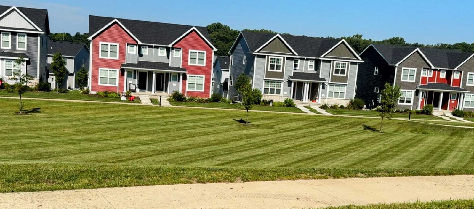 Freshly mowed lawn with perfect stripes in front of townhomes